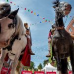 Two horses in Late Antique horse armour, photographed from below with a blue sky above them