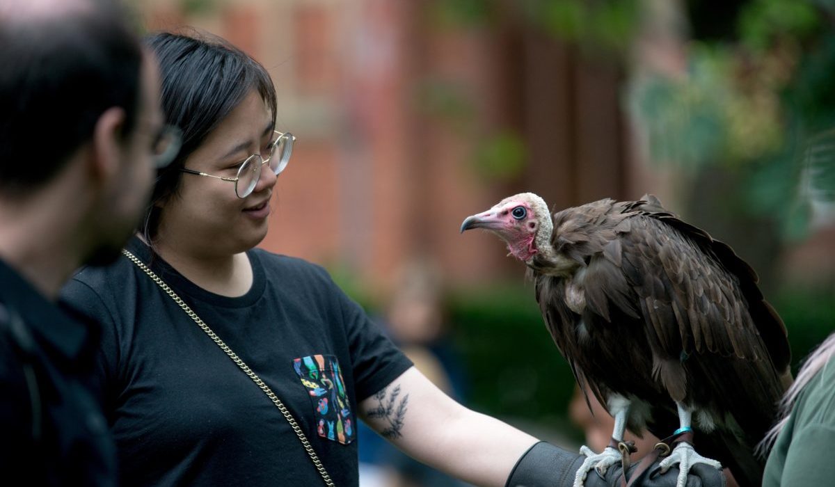 A female delegate holding a vulture on one arm