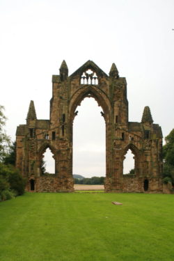 Guisborough ruins are pictured against a clear sky showing an impressive medieval gatehouse.