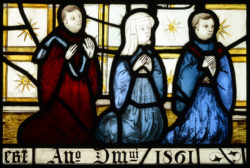 Close-up of stained glass window from All Saints church, North Street, York depicting three seated figures wearing robes.