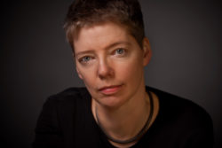 A portrait photo of Nicola Griffith facing the camera against a dark background. Credit: Jennifer Durham