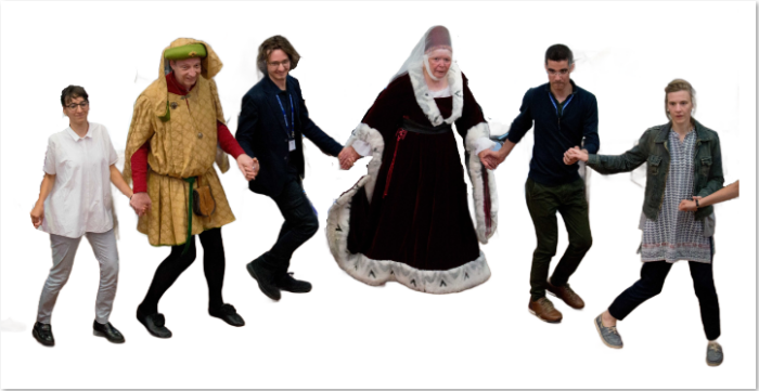 A picture of people in medieval dress and delegates holding hands and dancing.